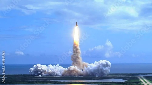 Space shuttle lifting off over water