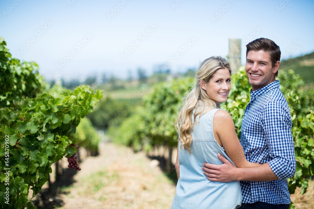 Portrait of couple embracing at vineyard