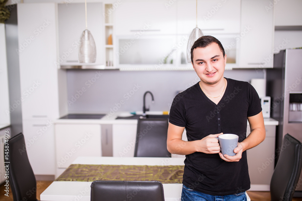 Portrait of handsome man drinking coffee in home kitchen Portrait of handsome man drinking coffee in home kitchen