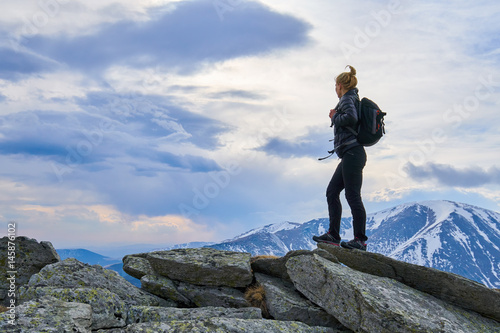 Woman hiker with backpack in the mountains