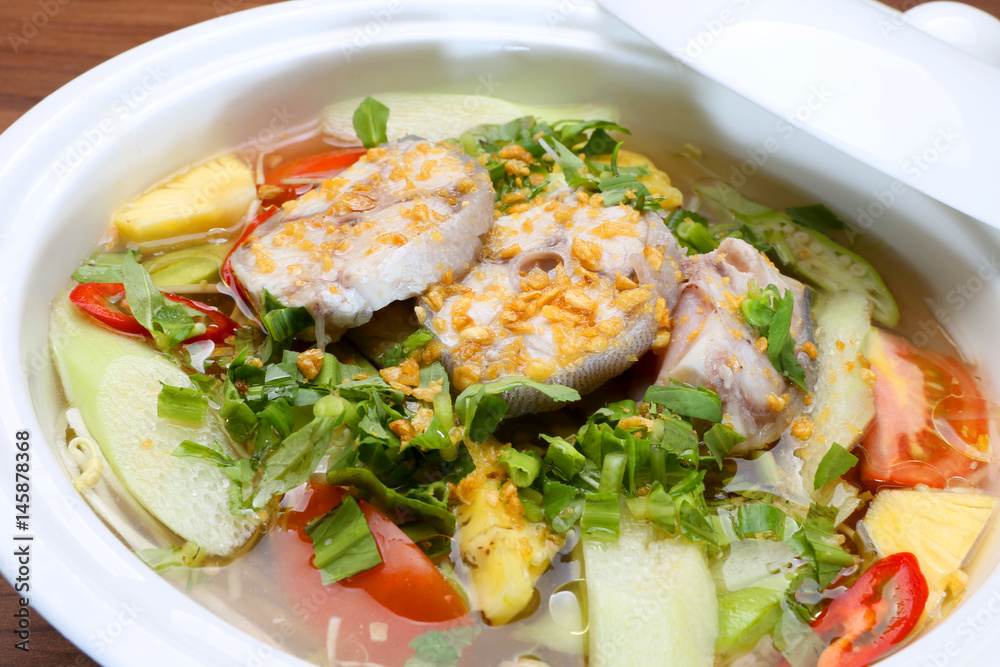 Sour soup in Vietnamese style with grouper fish in white bowl Sour soup in Vietnamese style with grouper fish in white bowl