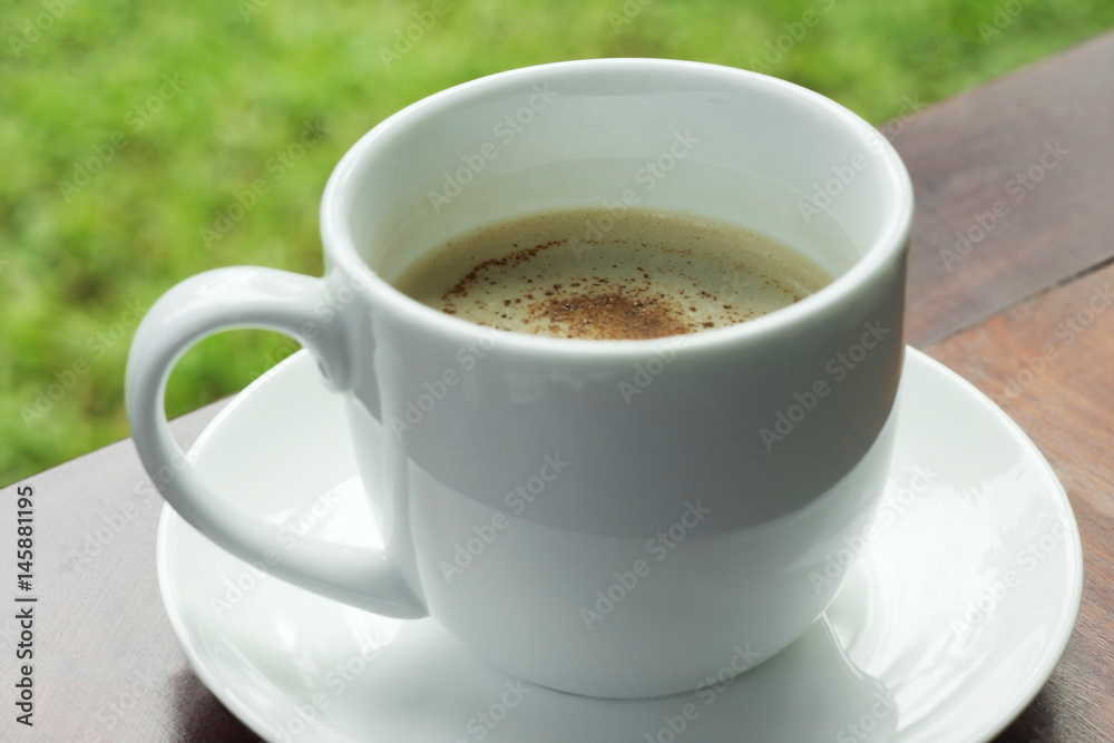 Cup of coffee on wooden table in garden. Cup of coffee on wooden table in garden.