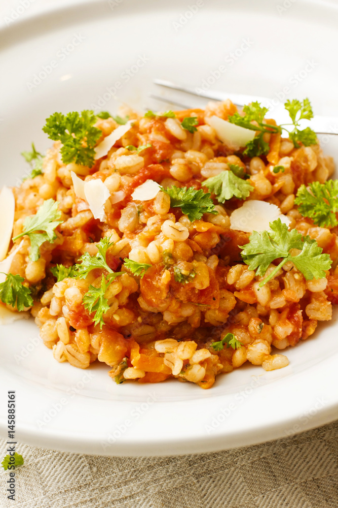 Pearl barley and tomato stew on white platter Pearl barley and tomato stew on white platter