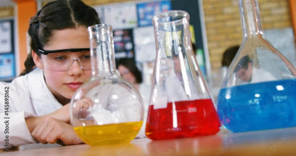 Schoolgirl observing chemicals in laboratory Schoolgirl observing chemicals in laboratory