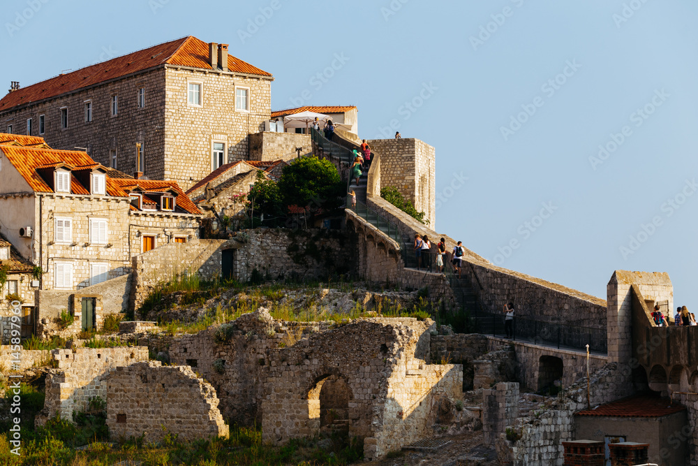 People on a protective wall in the old city of Dubrovnik, Croatia.