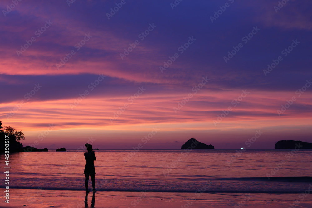 women stand on beach in sunset time, she feeling alone, no more people