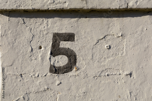House number 5 sign painted on wall