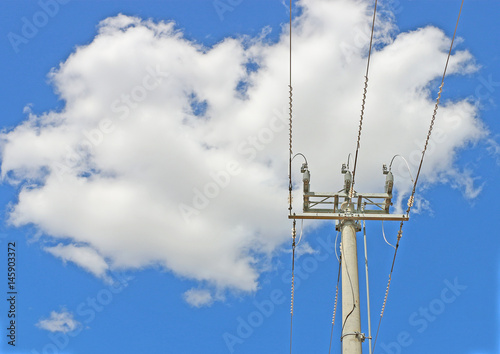 cement power pole and three power electricity lines in cloudy blue sky photo