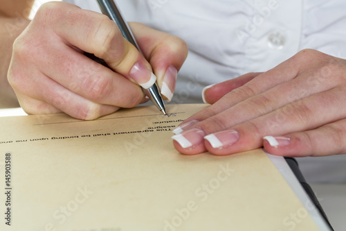 Hand mit Füllfeder unterschreibt Vertrag