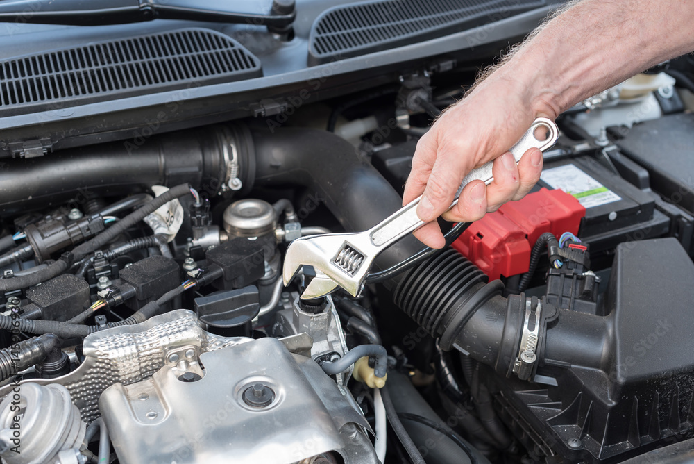 Hands of car mechanic working on car engine Hands of car mechanic working on car engine
