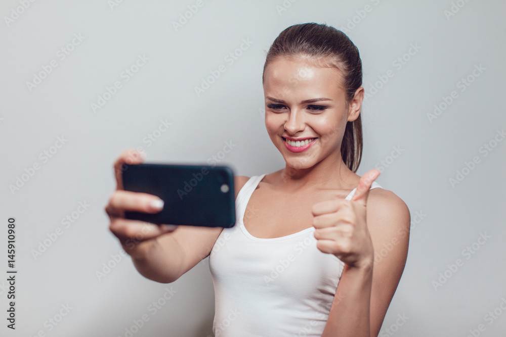 Young smiling woman having fun and make selfie on white background. Young smiling woman having fun and make selfie on white background.