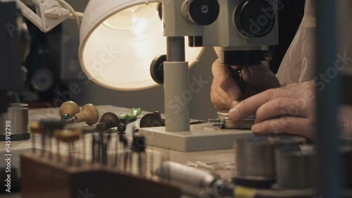 A jeweler by the microscope photo
