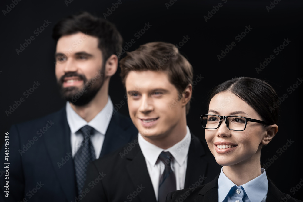 group of smiling business people standing in row isolated on black group of smiling business people standing in row isolated on black