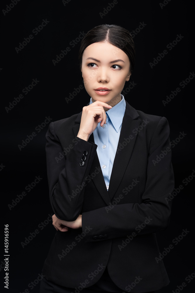 brunette pensive businesswoman in black suit isolated on black brunette pensive businesswoman in black suit isolated on black