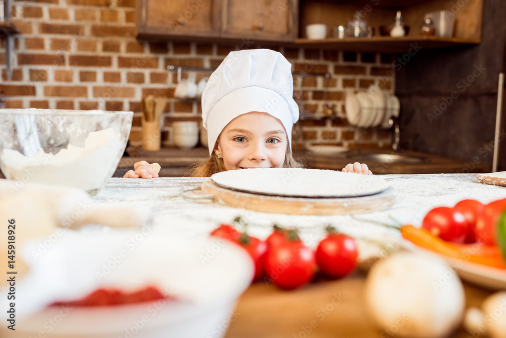 little girl making pizza dough with pizza ingredients in kitchen little girl making pizza dough with pizza ingredients in kitchen