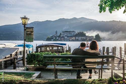 Foto Couple in the background of lake and Orta San Giulio island