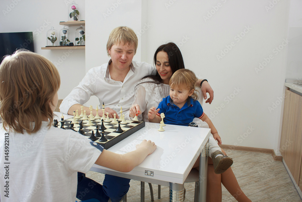 Obraz premium Family playing chess on a table at home