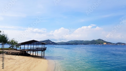 Wooden beach shelter and beautiful tropical sea, mountain and blue sky background, summer holidays concept