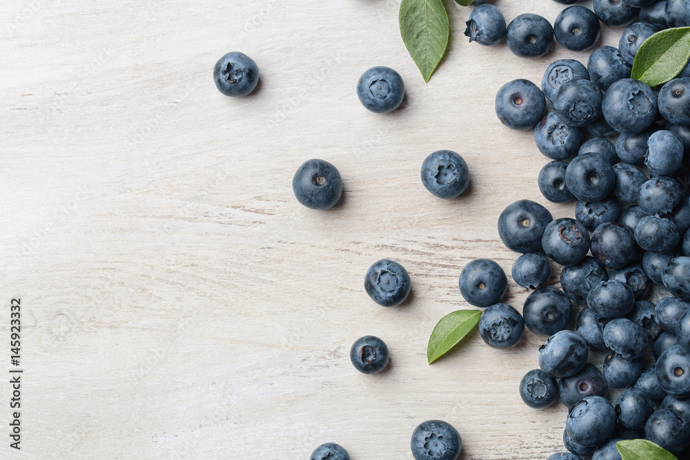 Freshly picked blueberries spilled on the wooden background with copy space Freshly picked blueberries spilled on the wooden background with copy space