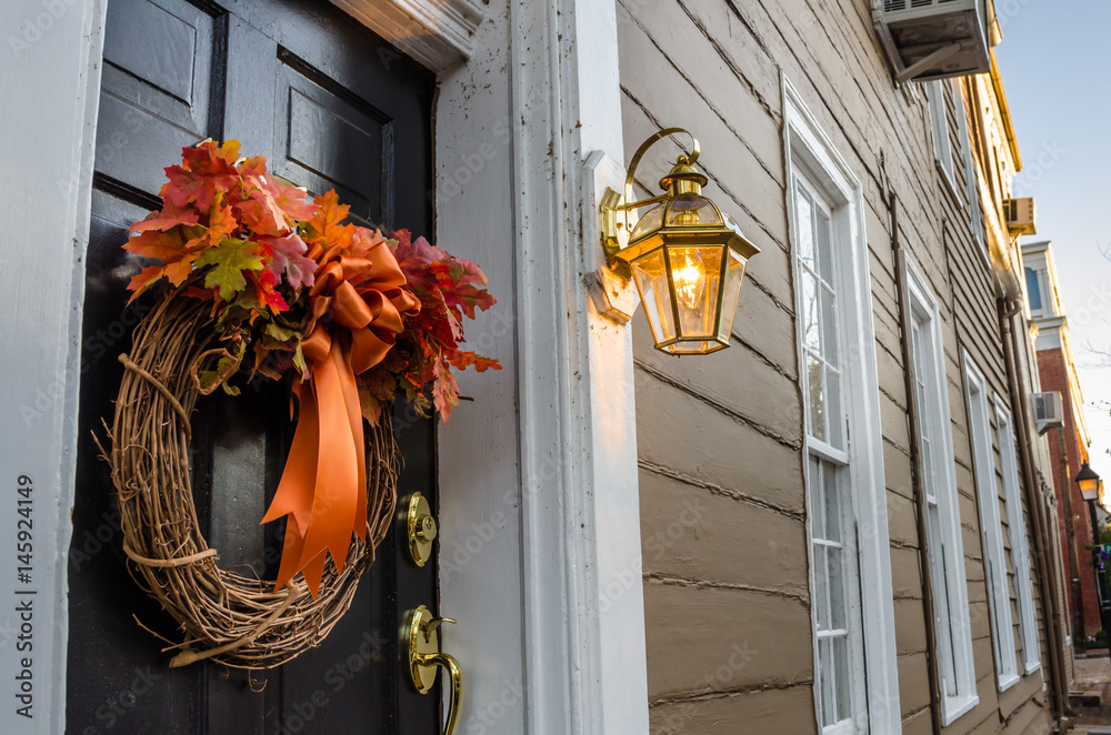 Naklejka premium Detail of a Black Wooden Door with a Halloween Wreath.