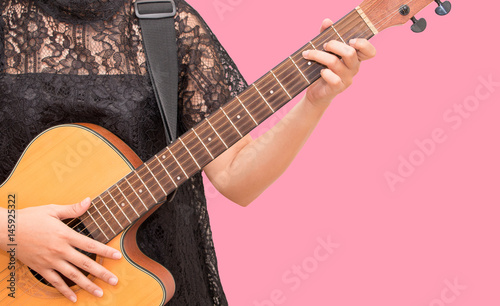 A woman playing acoustic guitar by chord C