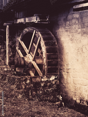 Old watermill wheel. Historical construction in rural region. Vintage style image. photo