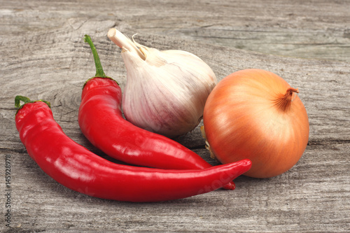 spices onion, garlic and chili pepper on old wood background