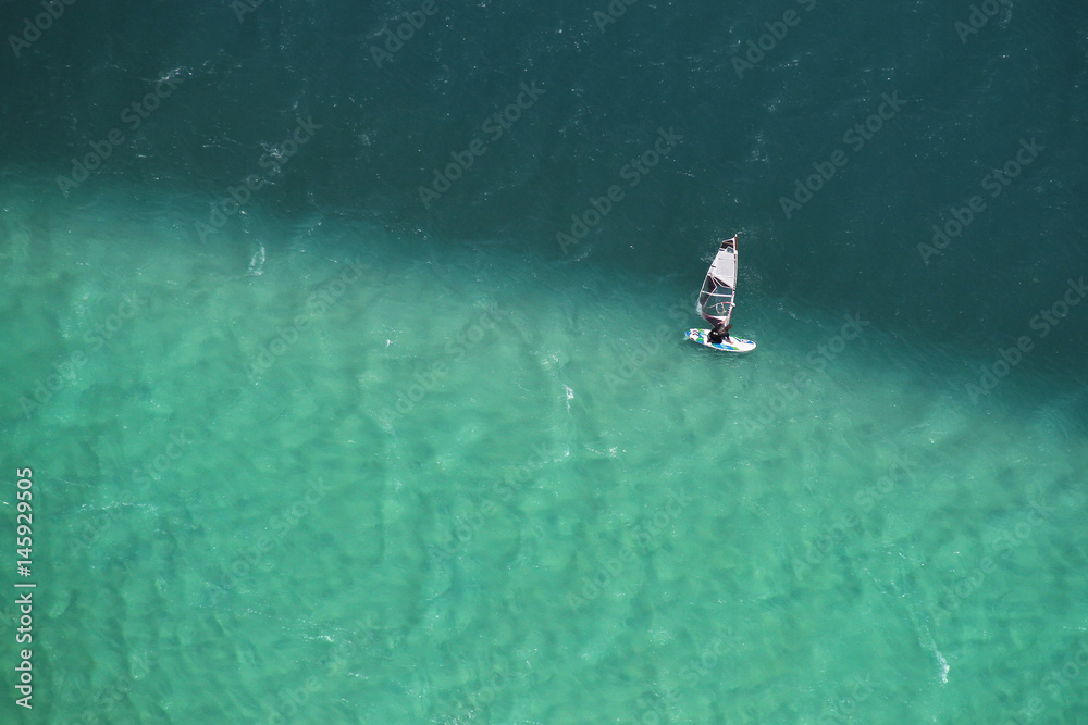Man windsurfing in two colored sea aerial photo.