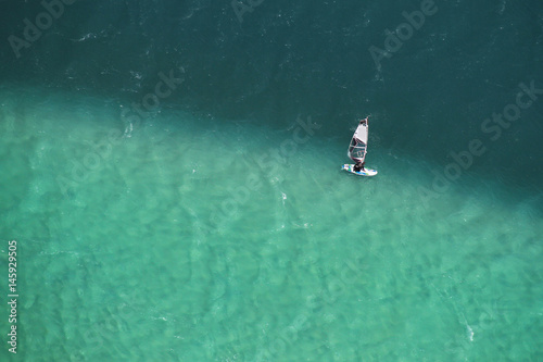 Man windsurfing in two colored sea aerial photo.
