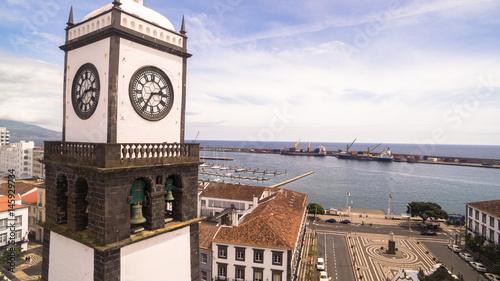 Saint Sabastian church with clock tower in Ponta Delgada on Sao Miguel Island in Azores, Portugal. Beautiful church in early morning under white clouds. photo