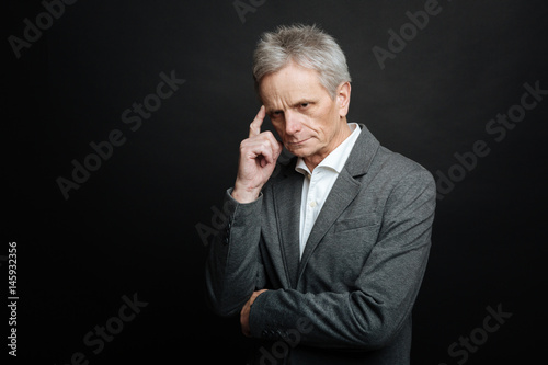 Concentrated aging man thinking about life indoors