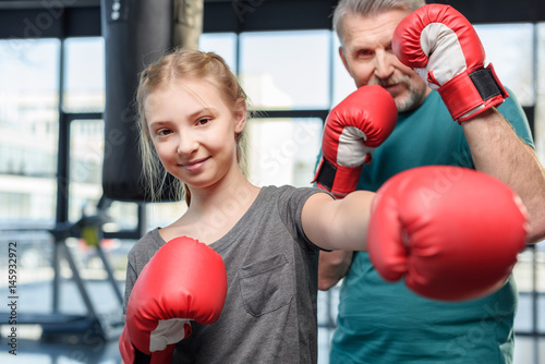 preteen girl boxing with senior trainer. Fitness manager, gym class kids concept © LIGHTFIELD STUDIOS