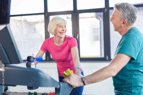 old sport couple training on treadmill in fitness class for senior people