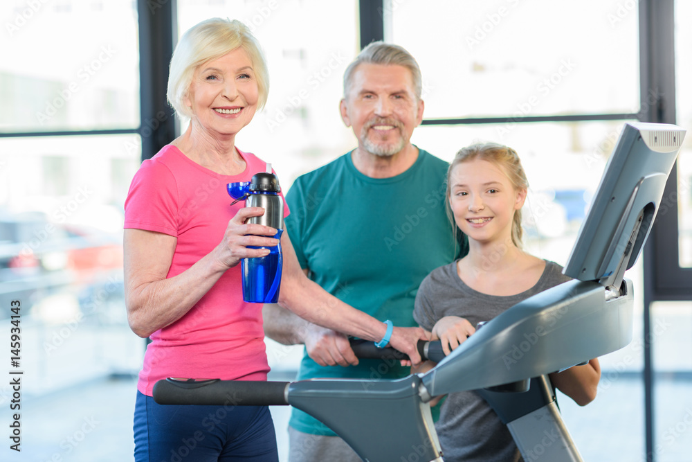 old sport couple and girl training on treadmill in fitness class