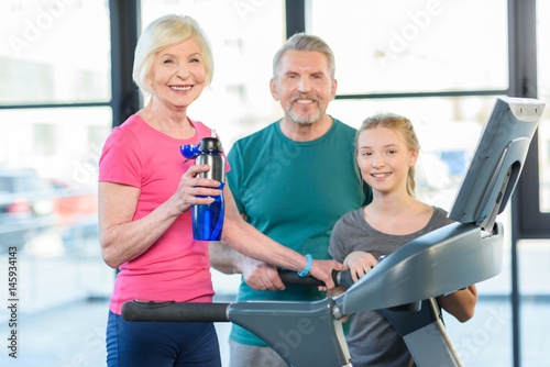 old sport couple and girl training on treadmill in fitness class