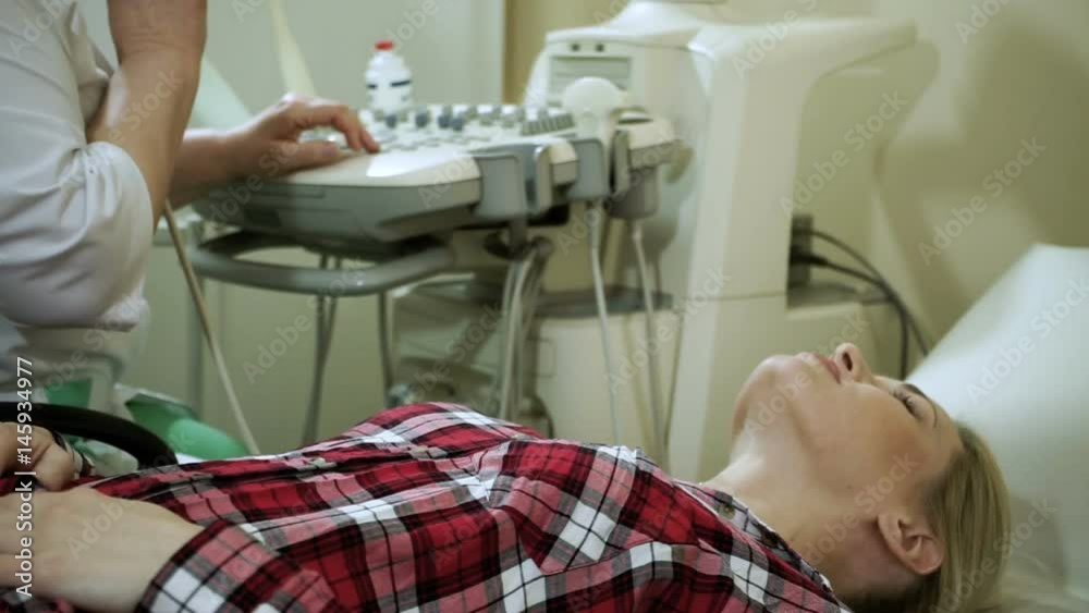 Female doctor examining the woman's thyroid gland using an ultrasound scanner. HD Female doctor examining the woman's thyroid gland using an ultrasound scanner. HD