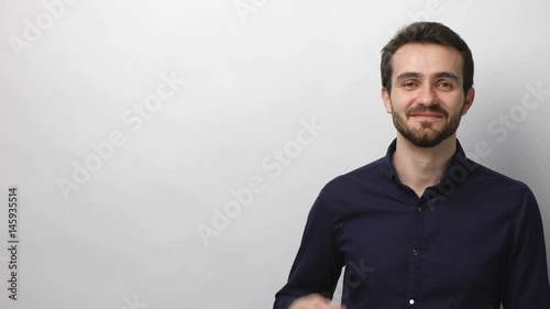 Smiling handsome young buisnessman showing holding on the palm blank copy space over white of background. Loked down real time video