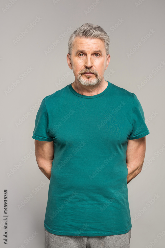 Confident mature fitness manager in sportswear standing isolated on grey Confident mature fitness manager in sportswear standing isolated on grey