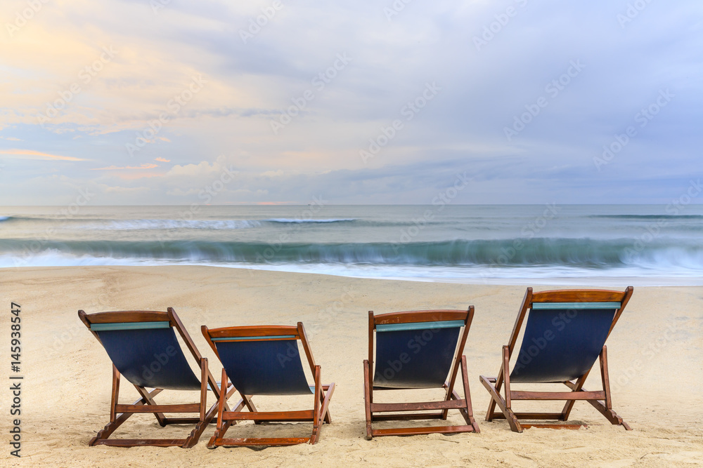 beach chairs on the sandy beaches for tourists to sit and relax with soft ocean waves breaking on beach