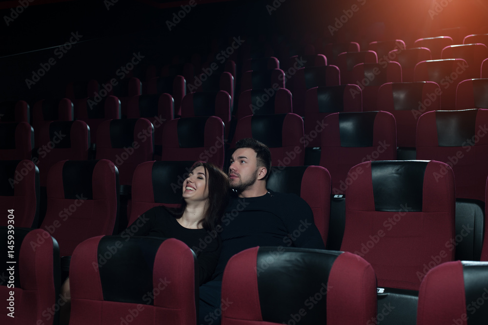 Young romantic couple watching movie in theater