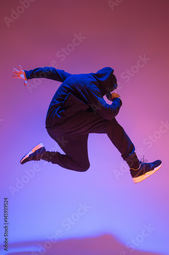 Obraz na plátně The silhouette of one hip hop male break dancer dancing on colorful background