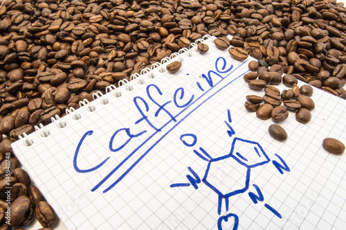 Notebook with text title caffeine and painted chemical formula of caffeine is surrounded by fried ready to use grains of coffee beans Fototapeta