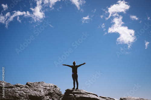 Woman on top of a mountain.