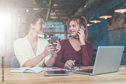 One-on-one meeting.Two young business women are sitting in office at table and working together.