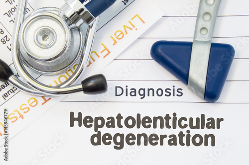 Diagnosis Hepatolenticular Degeneration. Neurological hammer, stethoscope and liver laboratory test lie on note with title of Hepatolenticular Degeneration. Concept for neurology and gastroenterology photo