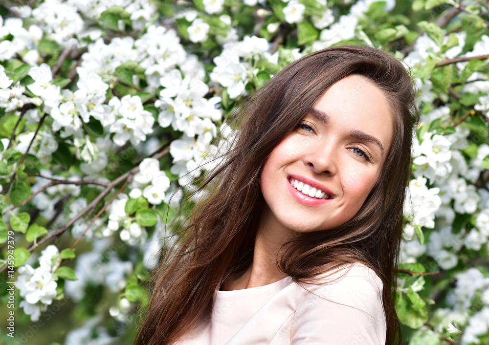 Happy young woman in a flowering spring garden. Spring time. Flowers blossoms. Happy young woman in a flowering spring garden. Spring time. Flowers blossoms.