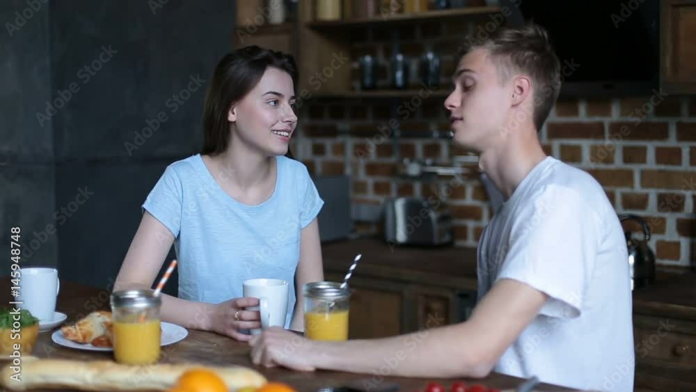 Loving couple having breakfast in modern kitchen Loving couple having breakfast in modern kitchen