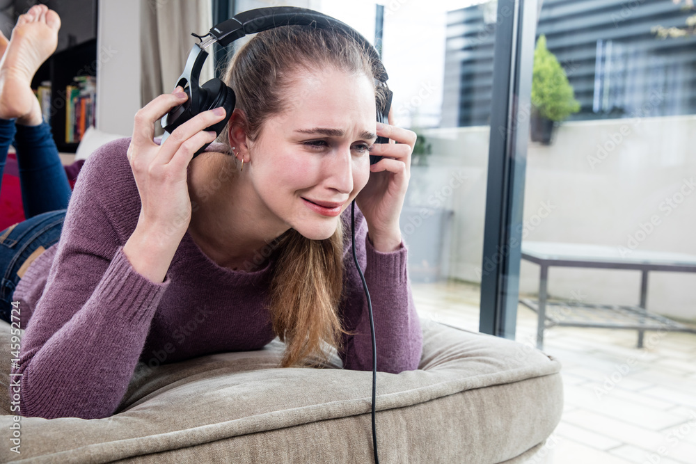 young woman crying in removing her headphones for noisy music Stock Photo |  Adobe Stock