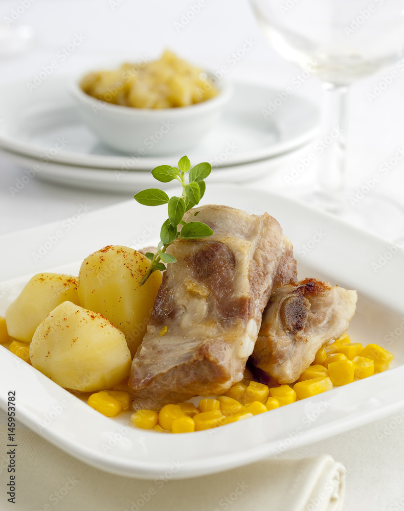 Gourmet pork ribs served with boiled potatoes and corn