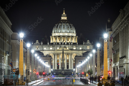 View of illuminated Saint Peter Basilica, Street Via della Conciliazione and light trails of cars in Rome, Italy